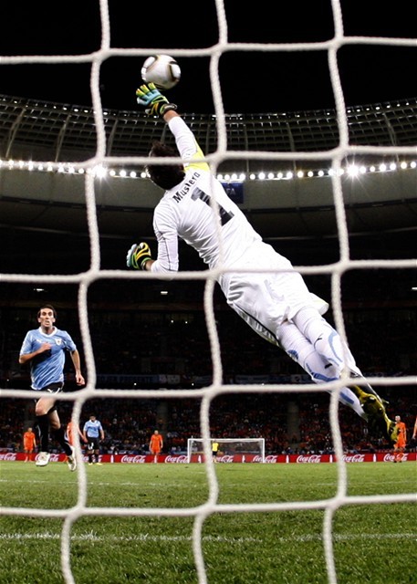 Brankár Uruguaja Fernando Muslera sa márne načahuje za
loptou.