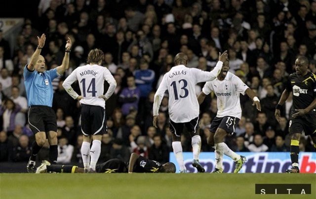 Hráči Tottenhamu aj rozhodca Howard Webb alarmujú
zdravotníkov, aby čím skôr prišli k Fabricovi Muambovi.