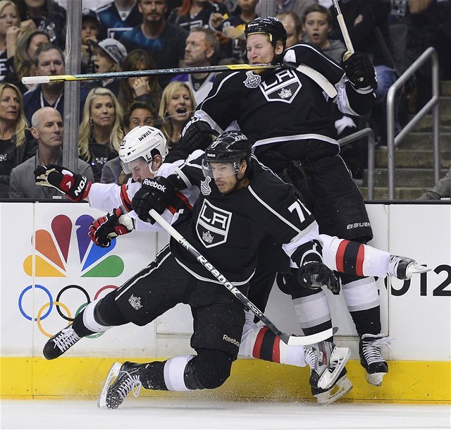 Jordan Nolan (v popredí) a jeho spoluhráč z Los Angeles
Matt Greene zastavujú Ryana Cartera z New Jersey.