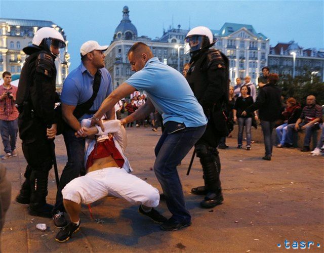 Poľskí policajti v civile zatýkajú nespratného
fanúšika.
