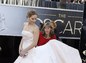 Asistentka upravuje šaty herečky Jennifer Lawrenceovej. 