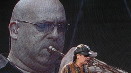 Carlos Santana, za ním na obtazovke trúbkár...