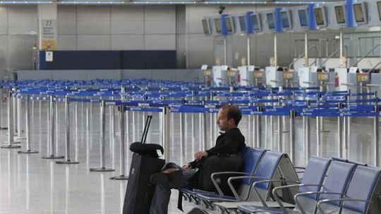 Nešťastný cestujúci sedí v prázdnej hale...