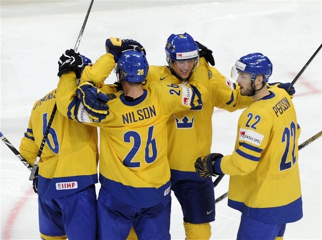 Švédski hokejisti sa tešia po góle v sieti...