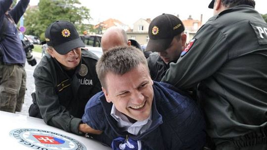 Policajti odvádzajú aktivistu Alojza Hlinu.