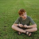 autizmus - dieťa - tráva - smútok - zamyslenie