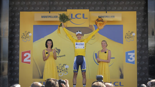 Daryl Impey v žltom tričku na pódiu.