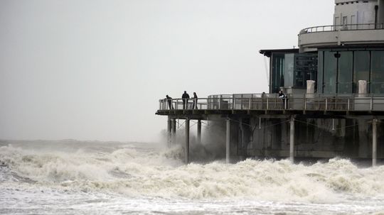Vlny udierajú na most v Blankenberge v Belgicku.