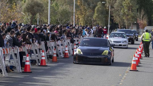 Fanúšikovia za zátarasmi sledujú príjazd...