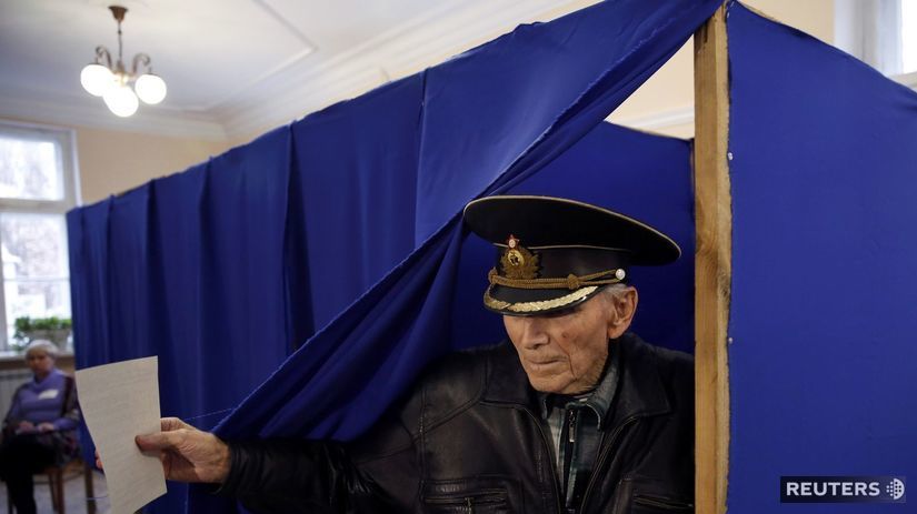 Muž s hlasovacím lístkom vychádza z volebnej...