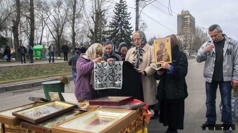 Ľudia sa modlia neďaleko budovy centrály tajnej...