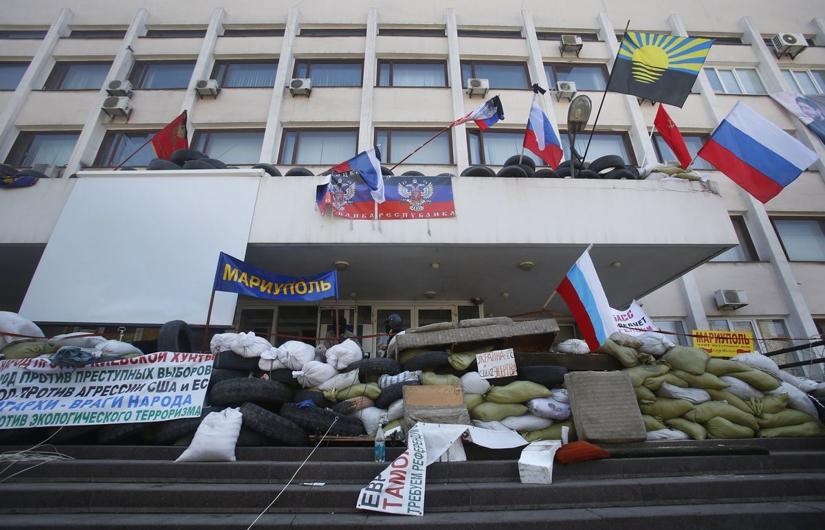 Maskovaní proruskí protestanti stoja za...