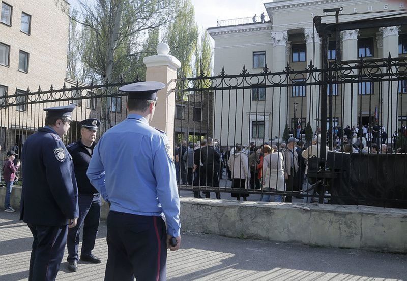Ukrajinskí policajti sa pozerajú, ako sa...