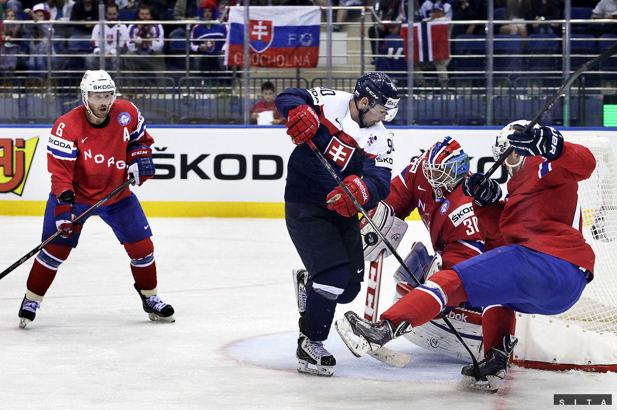 Tomáš Tatar sa snaží pretlačiť puk za Larsa...