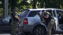 Proruskí ozbrojenci so zbraňami v okolí...