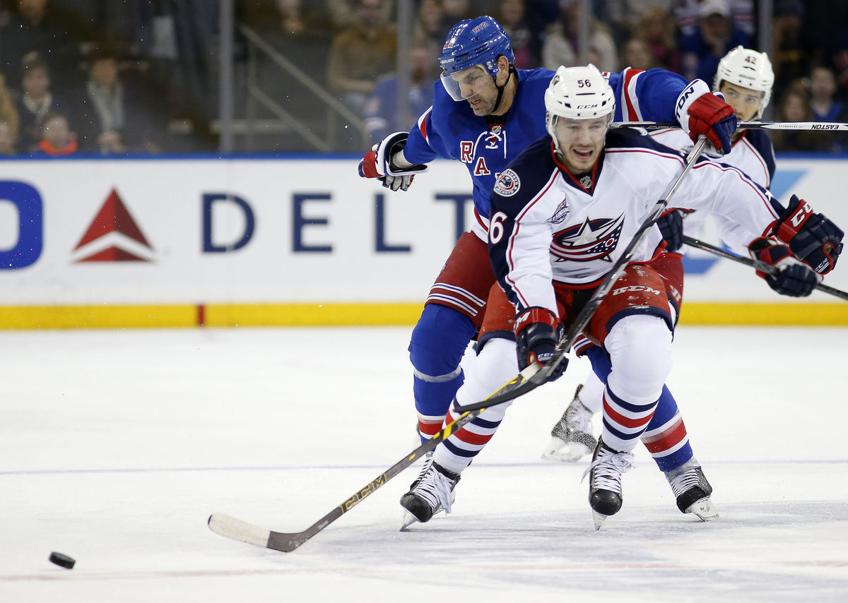 Obranca Dan Boyle z N.Y. Rangers zozadu napáda...