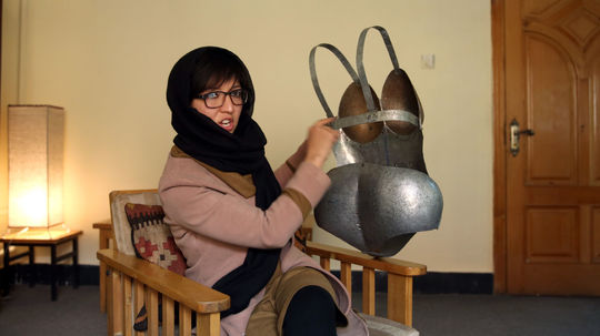 Kubrá Chádemíová ukazuje zadnú časť plechového...