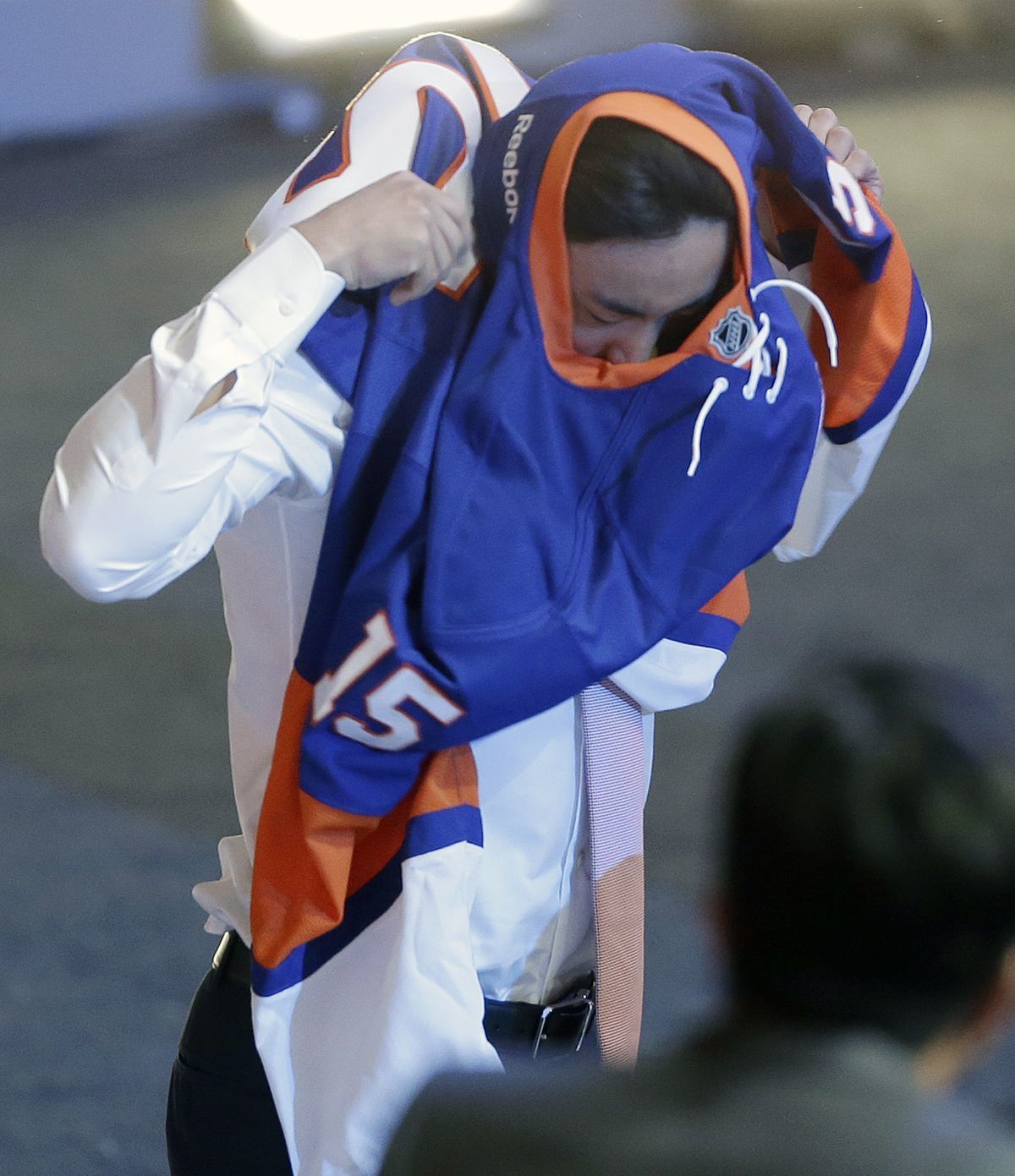 Andong Song z Číny si oblieka dres Islanders.