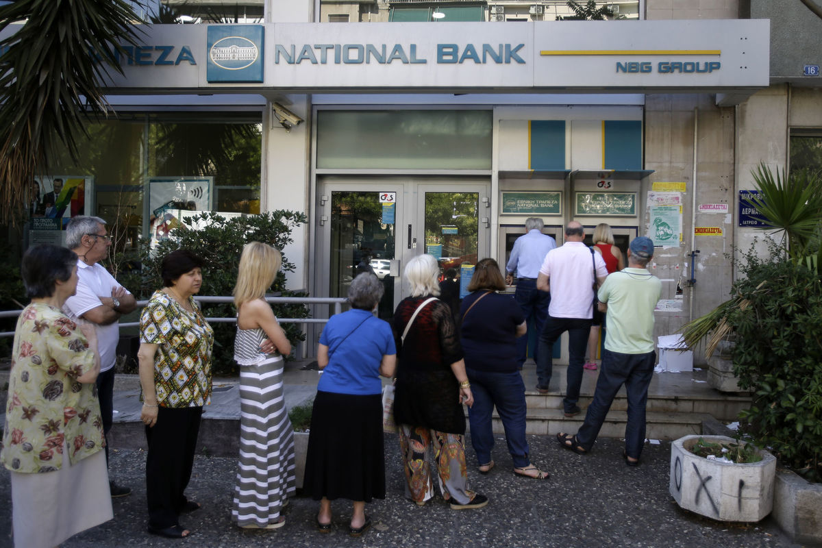 Ľudia stoja v rade pred bankomatmi.