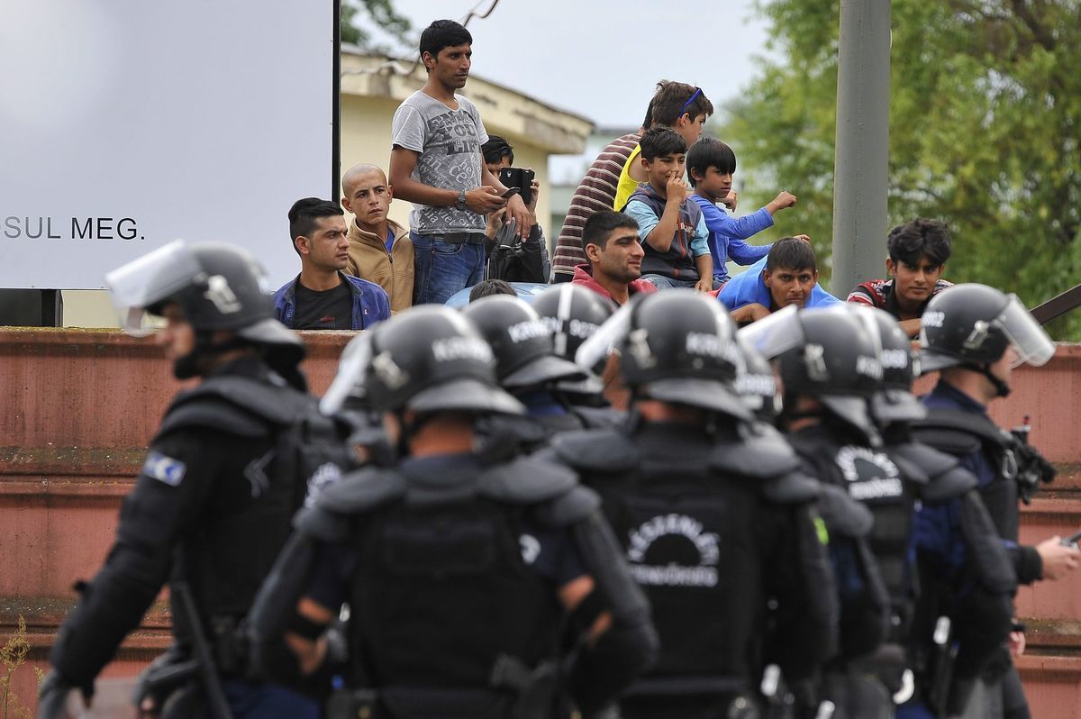 Policajti pred utečeneckým táborom v Debrecíne,...