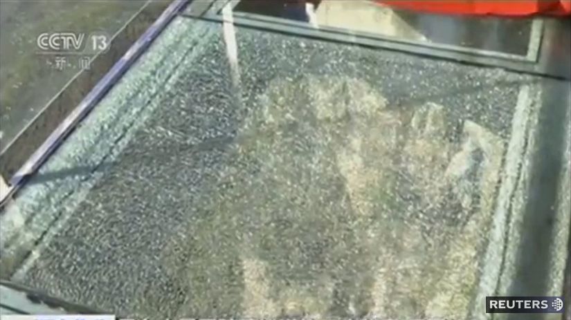 Praskliny v sklenenej tabuli chodníka.