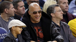 Herec Vin Diesel sleduje basketbalový zápas so svojím synom Vincentom.
