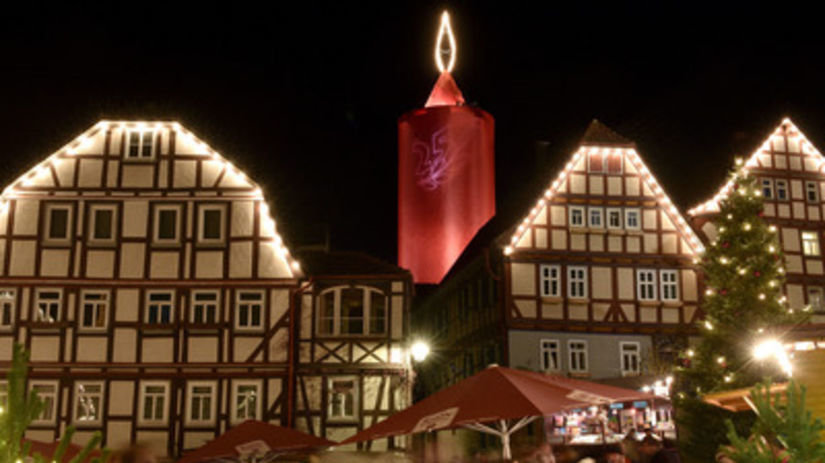 Hrazdené domy sú osvetlené obrou sviecou, ktorá...