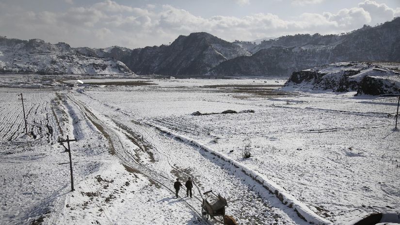 Zima v KĽDR. Dvaja farmári a ich kravami ťahaný...