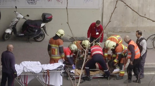 Záchranári odnášajú na nosidlách osobu z miesta...