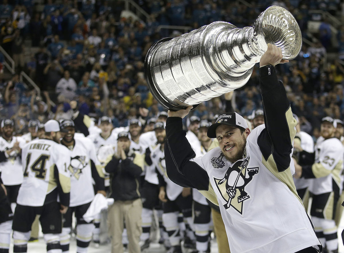 Kapitán Sidney Crosby drží nad hlavou Stanleyho...