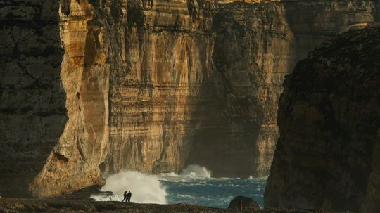Malťania sa dívajú, ako sa lámu vlny na skalách...
