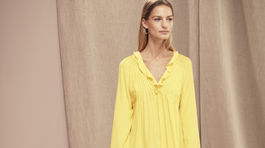 Modelka v žiarivých žltých šatách. Model na snímke Makrs & Spencer.