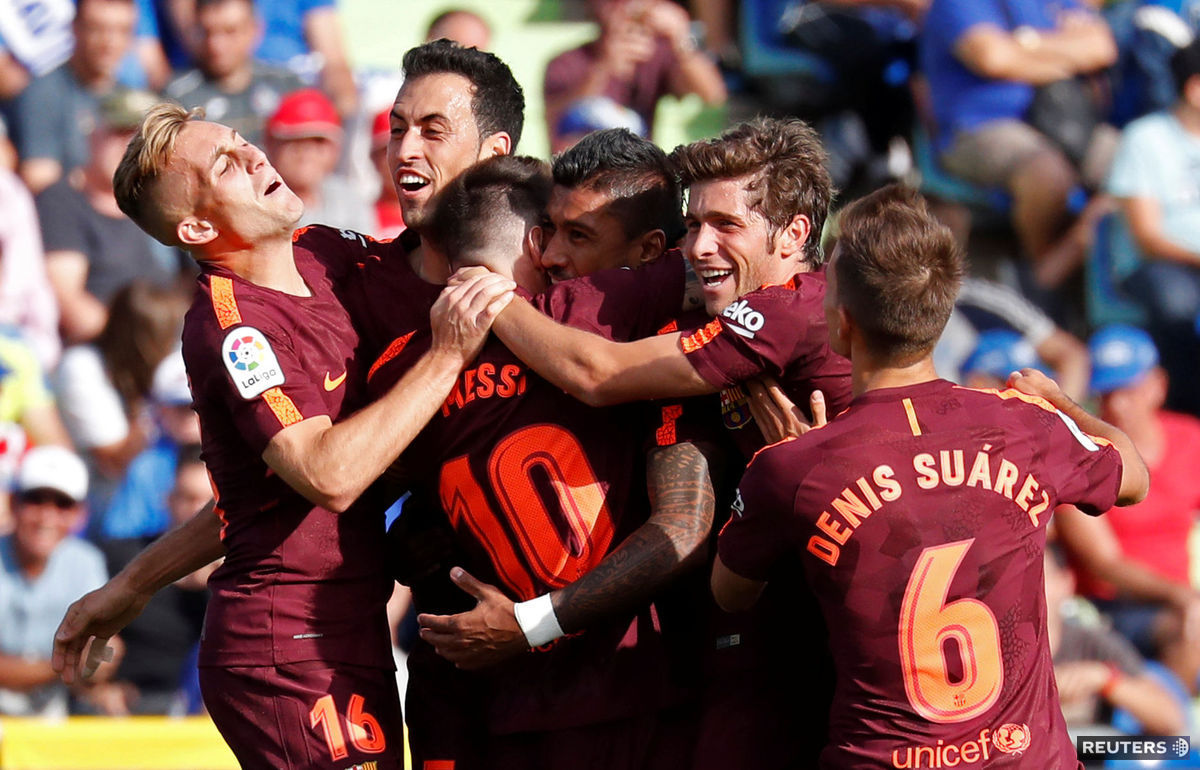 Futbalisti FC Barcelona oslavujú gól Paulinha...