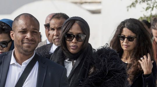 Utrápená Naomi Campbell na pohrebe. V pozadí za...