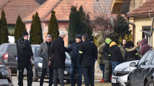 Na snímke policajti a kriminalisti v obci Veľká...