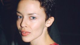 1996: Speváčka Kylie Minogue s krátkymi tmavými vlasmi na módnej šou. 