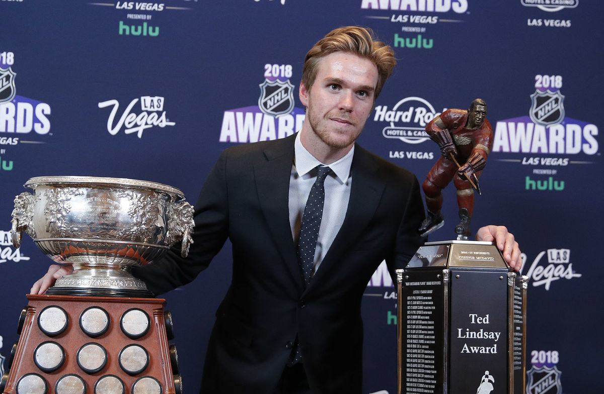 Connor McDavid pózuje s Art Ross Trophy (vľavo)...