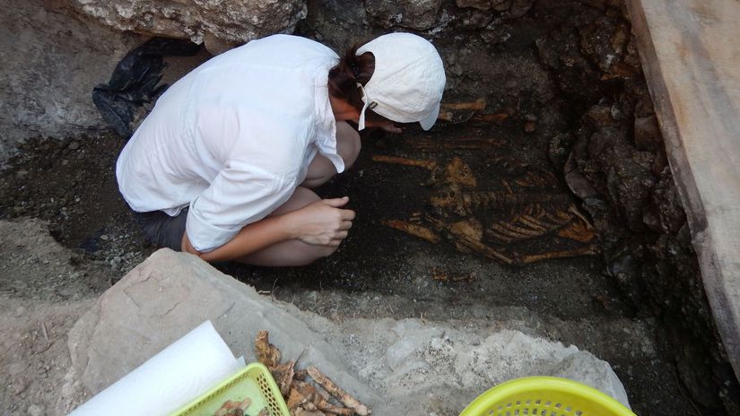 Archeologička pri čistení hrobového a...