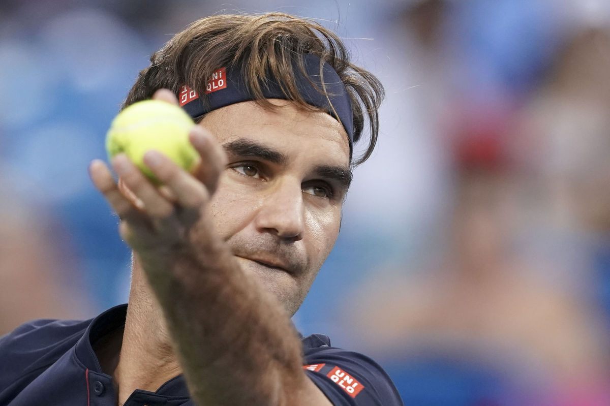 Roger Federer podáva v zápase proti Davidovi...