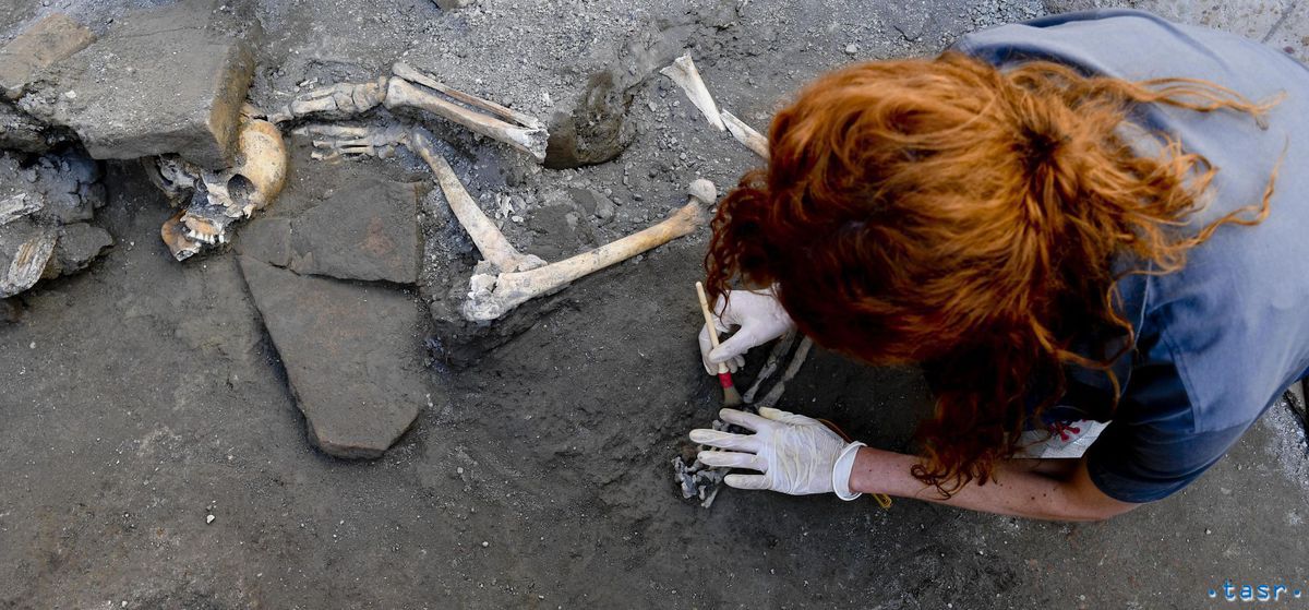 Archeologička skúma ľudské kostry na...