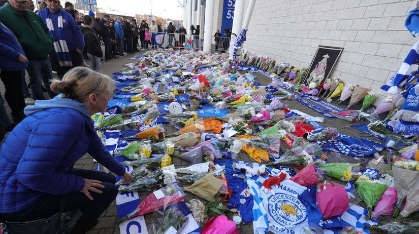 Fanúšikovia pokladajú kvety pred budovu...