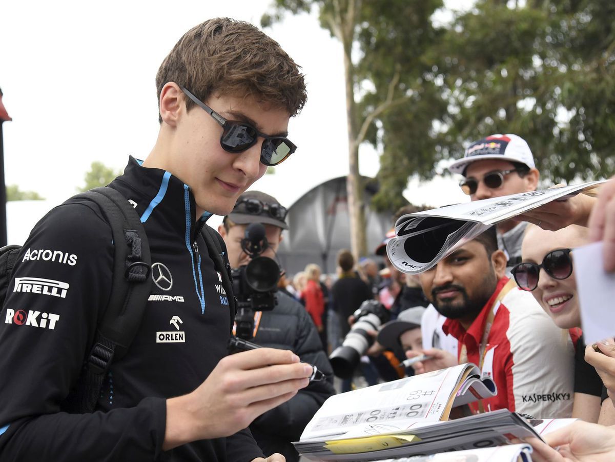 George Russell rozdáva autogramy fanúšikom.