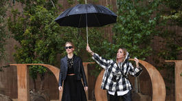 Asistentka chráni herečku Jennnifer Lawrenceovú pred dažďom, ktorý sa spustil pred prehliadkou Christian Dior v Paríži. 