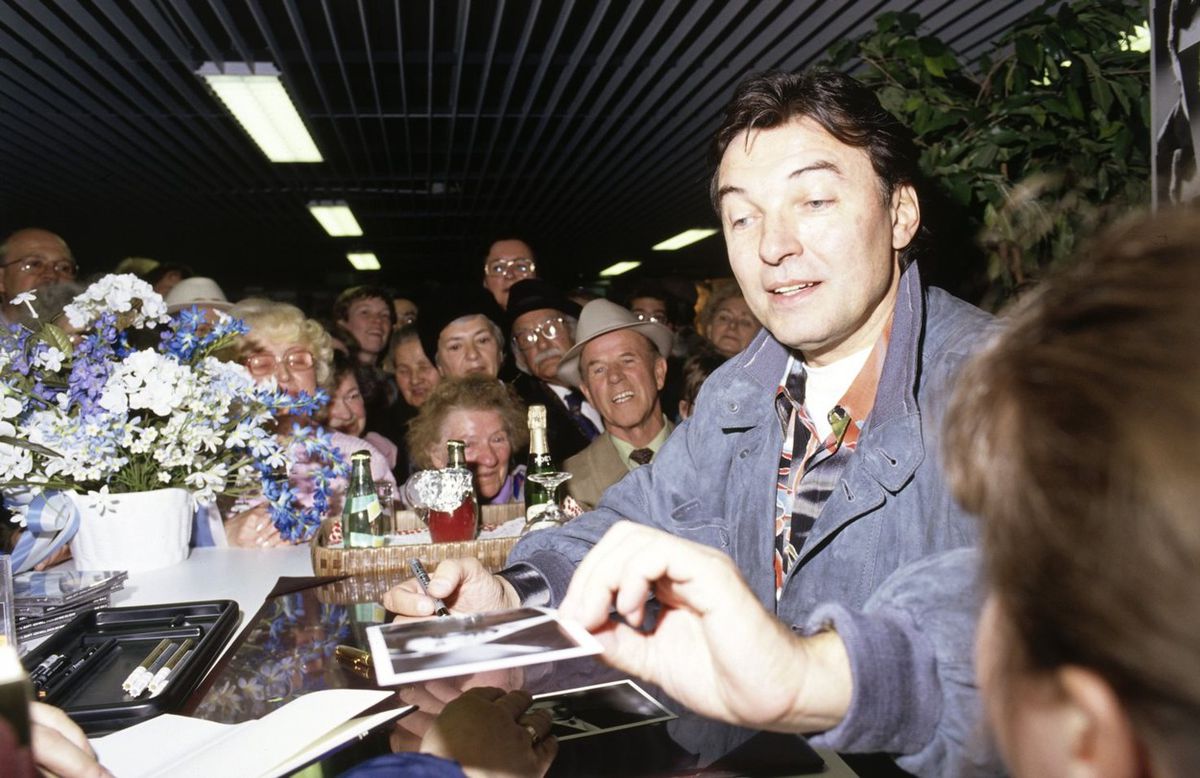 Spevák Karel Gott v roku 1990 rozdáva autogramy...