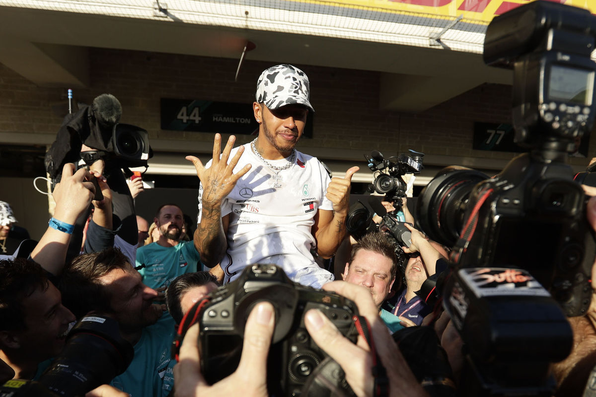 Lewis Hamilton ukazuje číslo 6 - počet titulov,...