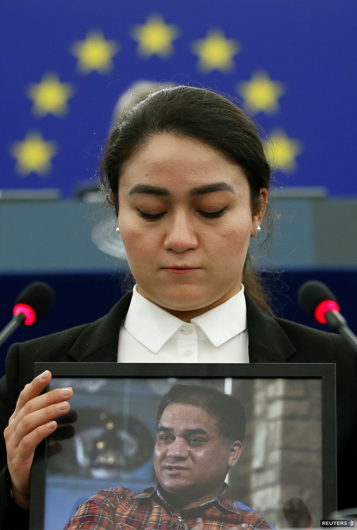 Aktivista Ilham Tohti na forografii, ktorú drží...