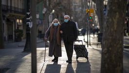 Starší pár kráča po ulici v Barcelone....