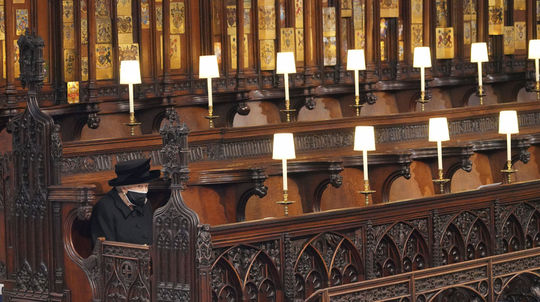 British Queen Elizabeth II.  she sits alone on the bench...