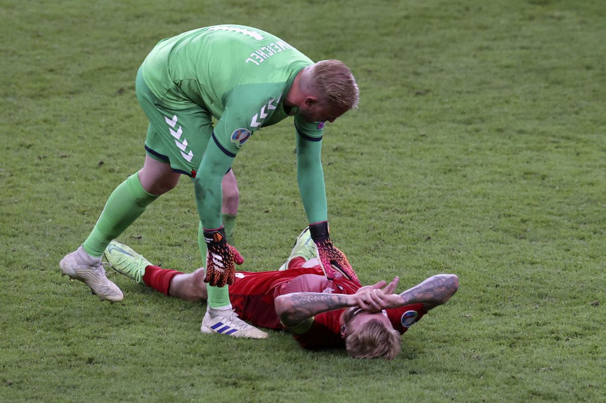 Kasper Schmeichel utešuje kapitána Simona Kjära...
