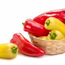 red and yellow pointed paprika in a basket. Isolate on white background 